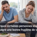 Homme et femme fatigués assis sur un canapé malgré une bonne hygiène de vie, illustrant la stagnation et les blocages invisibles du mieux-être
